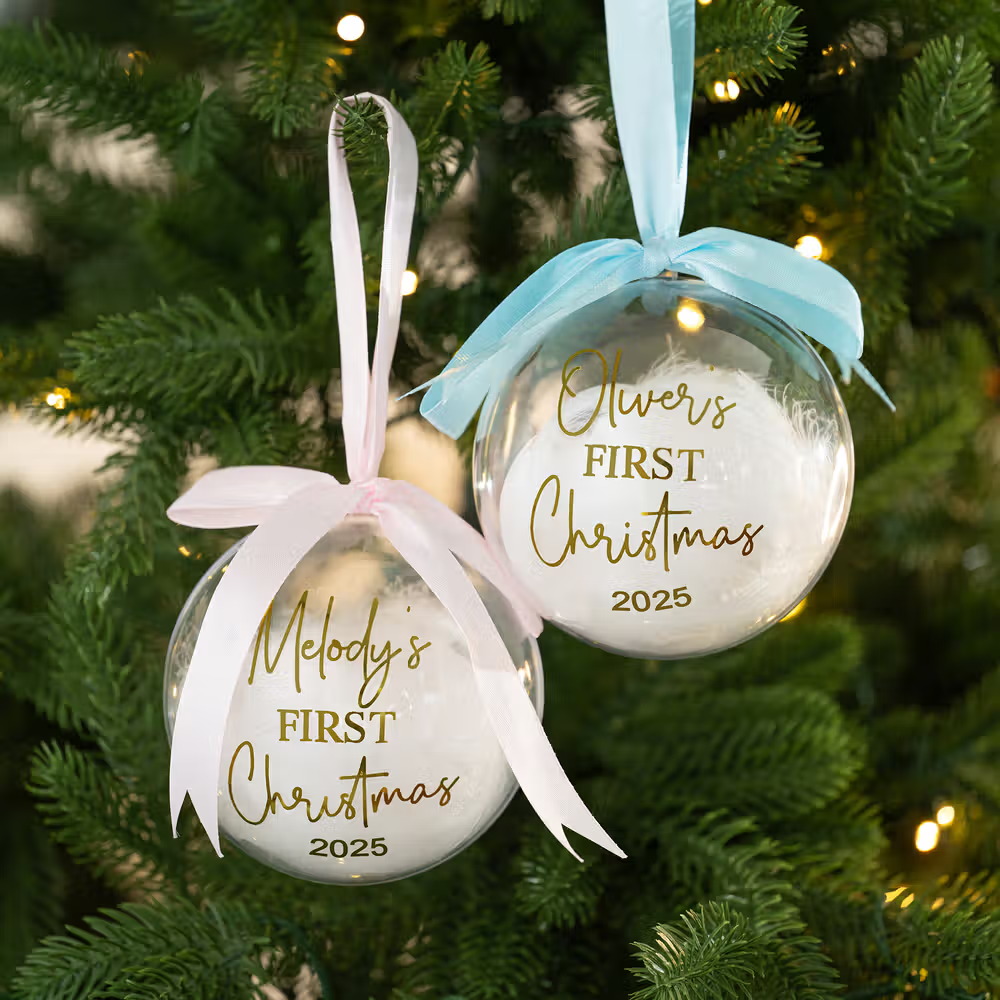 Fira en magisk högtid med en personlig julkula för bebisens första jul med fjädrar och namn
