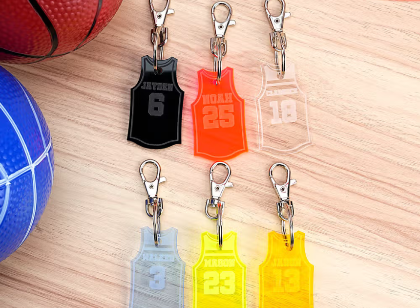 Visa din lagstolthet överallt med en personlig baskettröja i akryl som nyckelring eller väskmärke